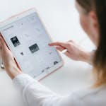 A woman interacts with a tablet to create digital art. Ideal for technology and creativity concepts.